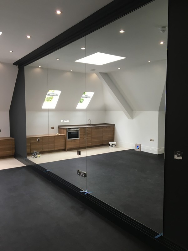 Frameless glass partition in loft conversion by East Finchley glaziers