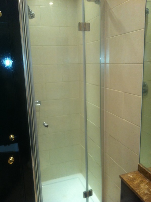 Frameless glass shower enclosure with chrome fittings in East Finchley