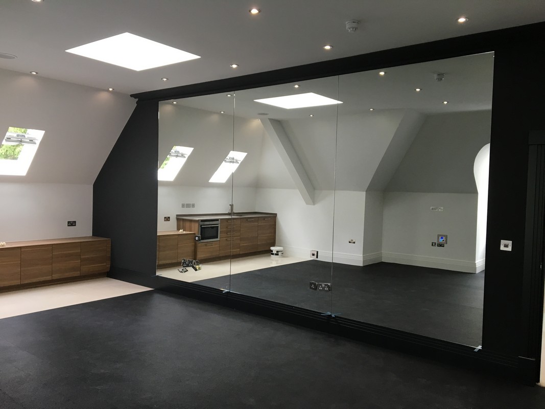 Frameless glass wall dividing loft conversion in East Finchley